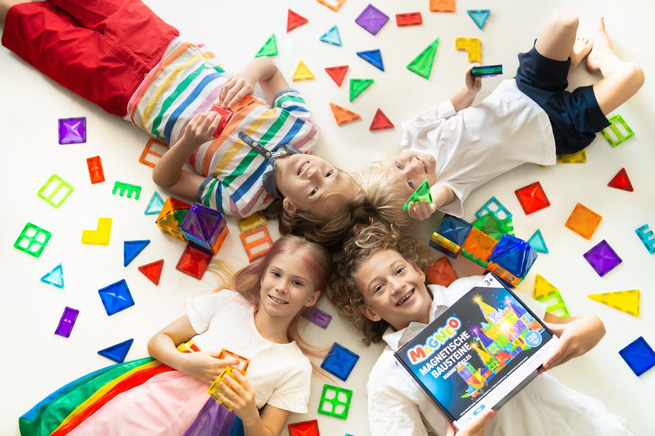 Glückliche Kinder bauen und träumen mit Magneo Magnetbausteinen, perfekt für bildschirmfreies Lernen und kreatives Spielen.